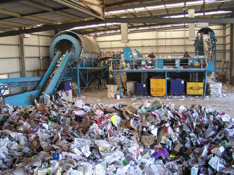 pile of unsorted recycling awaits trip into large sorting machine