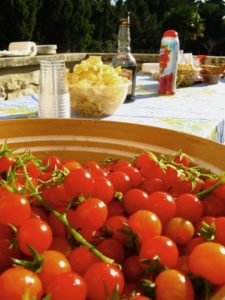 shared food at table and a large bowl of fresh cherry tomatoes