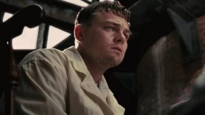 Leo DiCaprio viewed from a low angle. His eyebrows are pulled up and together and his eyes are red. He is frowning slightly.