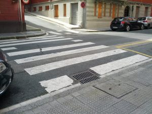 An image of a crosswalk with no sidewalk ramp.