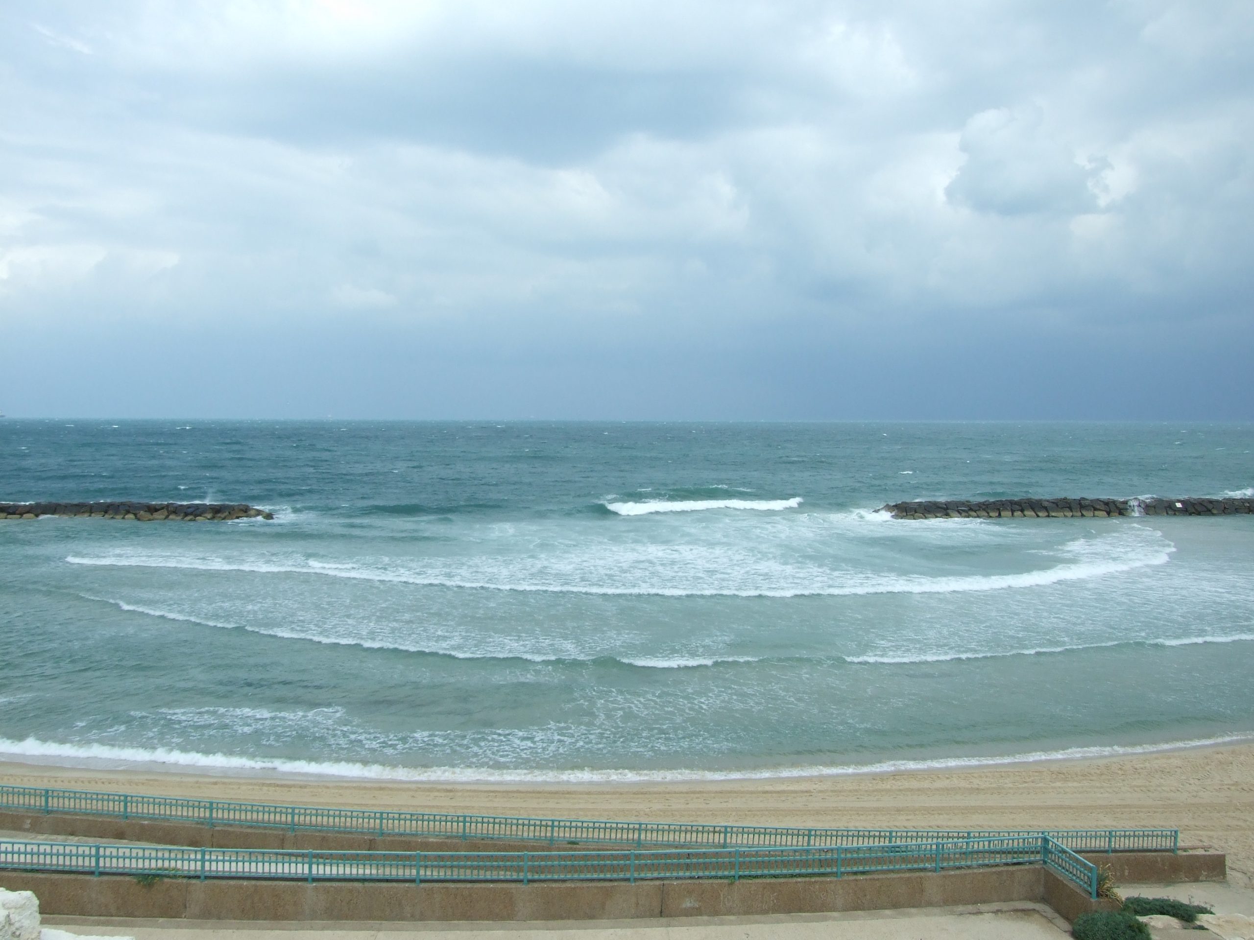 Waves approaching the beach from the ocean that pass through a breakwater form semicircular waves.