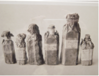 a black and white photograph featuring six bottles or vials of different sizes