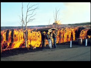 Photo of group of people by flowing lava