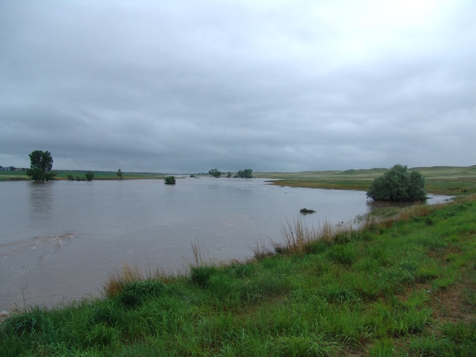 Photo of small stream valley full of water, 200 feet or more wide