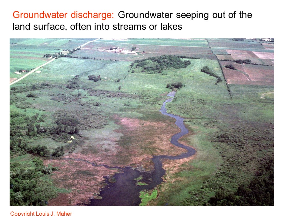 Photo taken from a small plane looking down on a wetland with a stream flowing out of it.