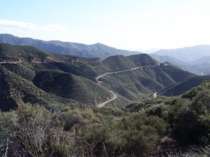 Mountainous landscape with a winding road. Shrubs dominate the vegetation.