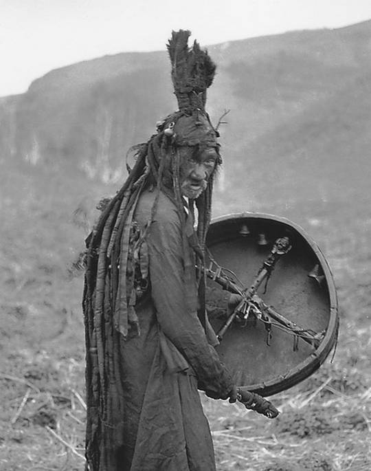 Kazakh shaman with traditional clothes and a percussion instrument