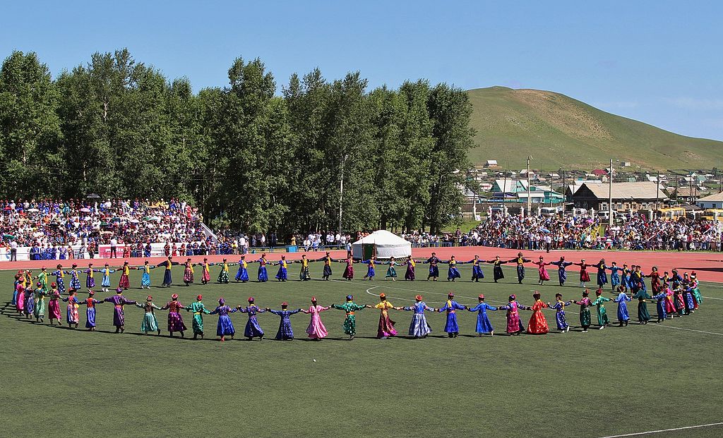 people in a circle dancing with Buryat costumes on