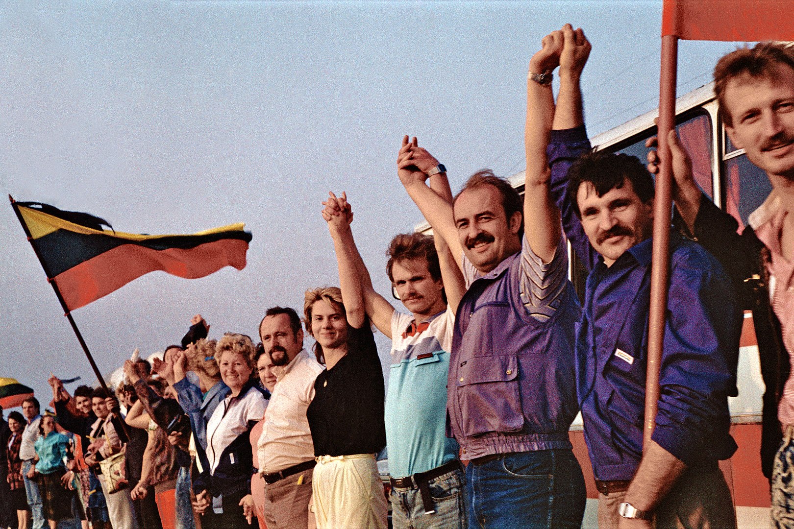 people standing with flags and holding hands