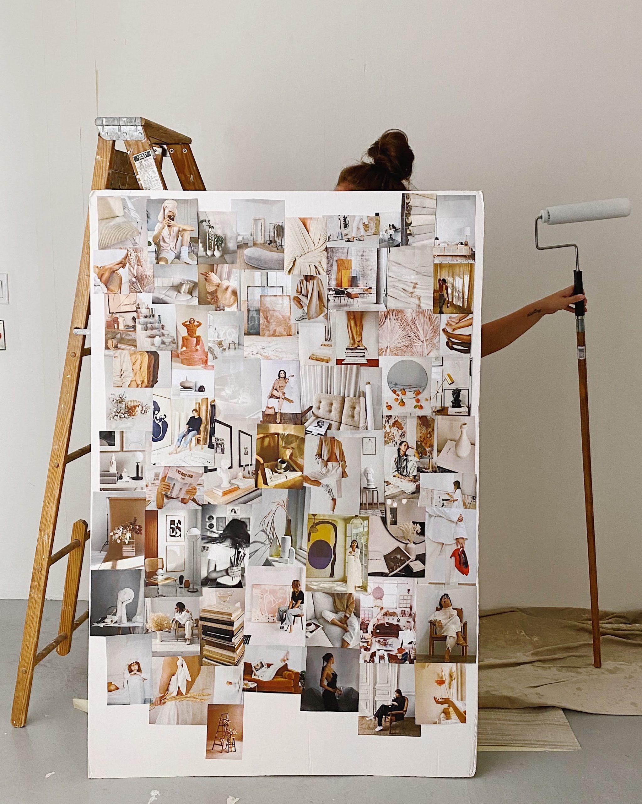 Woman painting a room that holds an inspiration board full of interior design photos