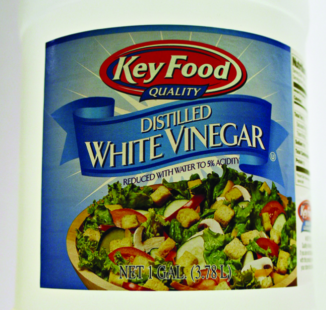 A label on a container is shown. The label has a picture of a salad with the words “Distilled White Vinegar,” and, “Reduced with water to 5% acidity,” written above it.